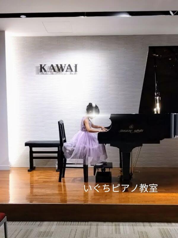 ピアノ教室の生徒さんがドレスを着て演奏している画像