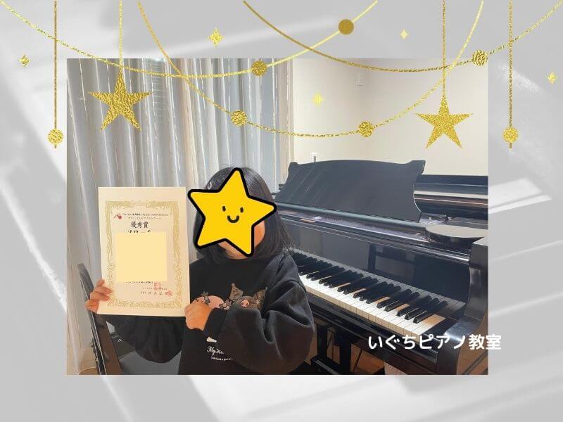 ピアノコンクールの賞状を持った生徒さんの画像